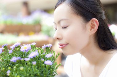 Çiçekçide çalışan genç Japon kadın çiçekçi.