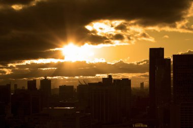 Gün batımında şehir binalarının silueti