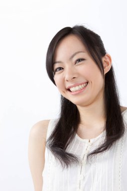 Beyaz arka planda gülümseyen Asyalı genç bir kadının portresi