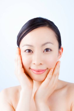 Genç ve güzel Asyalı kadın günlük cilt bakımını yapıyor.