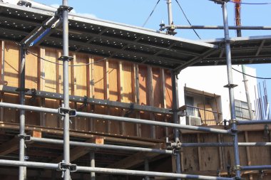 İnşaat halindeki ahşap binayı çevreleyen metal iskeleler.