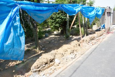 İnşaat alanının üzerinde asılı mavi muşambalar.