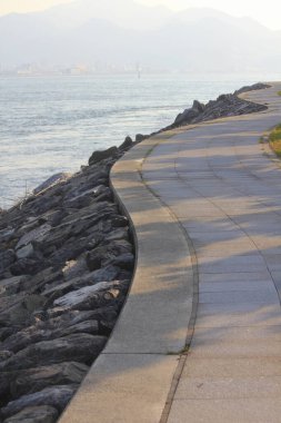 Boş yol ve kayalık deniz kıyısında akşam vakti