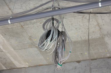 Bitmemiş beton tavan inşaat sahasının altında elektrik kabloları asılı