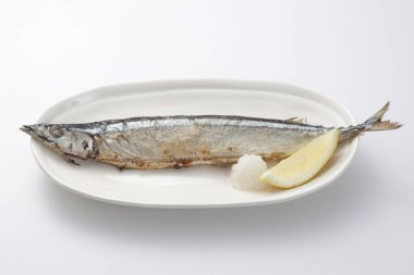 Beyaz tabakta limonlu uskumru ve biberiye.