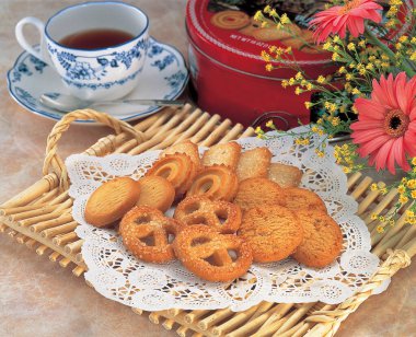 Kurabiye ve çay, masadaki çiçekler, yakın plan.