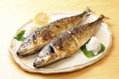 Arka planda limon olan bir tabakta iki balık, yakın plan.