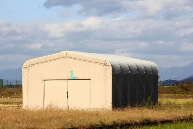 Kırsal alanda tek başına duran beyaz depo.