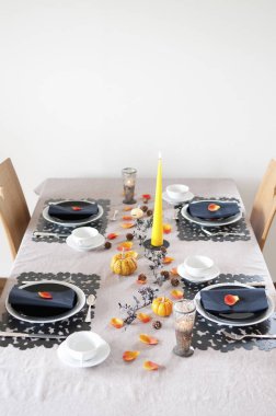 Balkabakları ve mumlarla şenlikli bir akşam yemeği için Şükran Günü sofrası.     