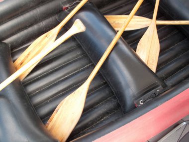 Siyah yüzeyi olan bir teknede tahta kürekler.