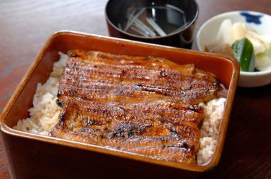 Izgara yılan balığı filetosu buharda pilavın üzerinde dinleniyor.