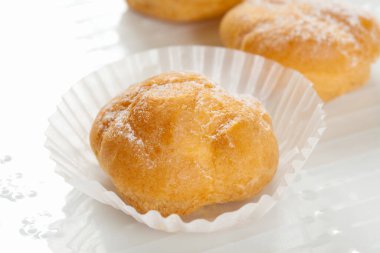 Beyaz zemin üzerinde pudra şekerli taze pişmiş çörekleri kapatın.