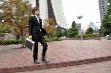 Asya işadamı şehirde yürüyüş