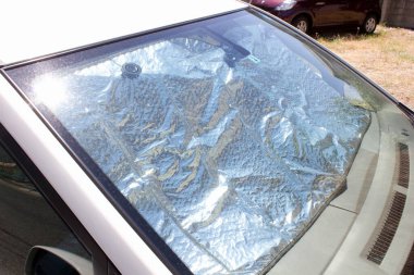 Gündüz vakti arabanın ön camında yansıtıcı güneş kremi var.