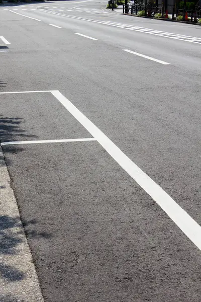 Siyah asfalt yolda beyaz park işaretleri 