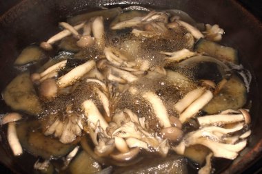 Tencerede mantar ve sebze pişirmek.