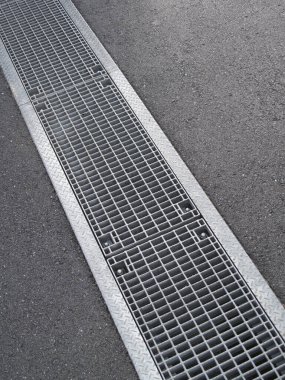 Asfalt yüzeyi üzerindeki metal ızgara kaplama drenajı