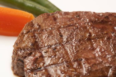 Arka planda sebzeli biftek.