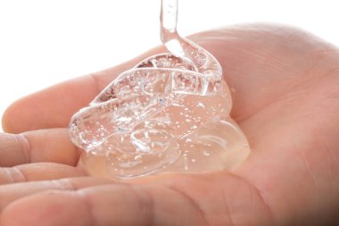 El ele tutuşan şeffaf şampuan, yakın görüş.