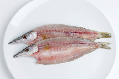 beyaz zemin üzerinde plaka üzerinde çiğ balık