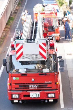 Şehir sokağına park etmiş kırmızı itfaiye araçları.