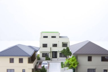 Beyaz arka plandaki küçük ev modelleri, ipotek kavramı