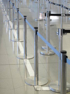 Sıra engelleri ve zemin katları olan boş havaalanı kayıt alanı