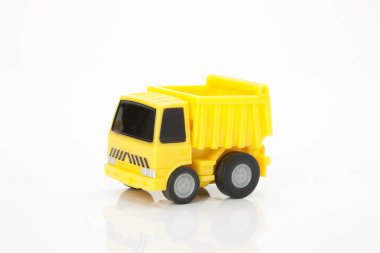 Beyaz arka planda sarı oyuncak kamyon