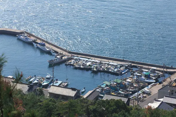 Sakin mavi deniz kıyısının yanındaki küçük marinaya yanaşan tekneler.