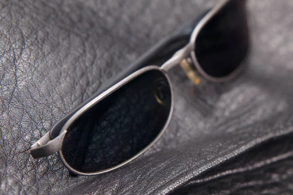 Zbliżenie Okularów Przeciwsłonecznych Czarnym Tle Skóry — Zdjęcie stockowe