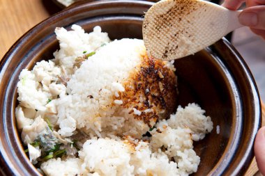 Kahverengi seramik kaseden çıtır çıtır pirinç çıkarıyorum.