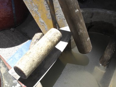 Su dolu beton kuyunun üzerinde duran tahta sopalar.