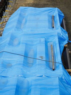 İnşaat malzemelerini kaplayan mavi branda.