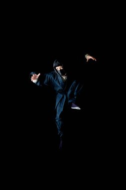 Ninja kostümlü genç adam atlıyor.