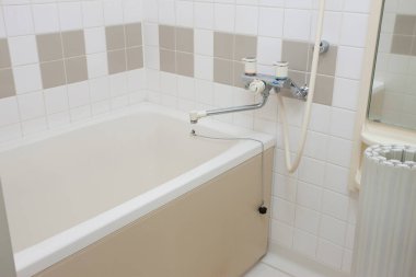 Duvar kiremitleri ve küvetli hafif banyo.