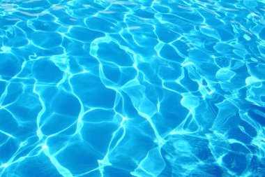 Dalgalar ve yansımalarla mavi yüzme havuzu suyu      