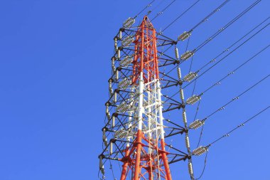 Mavi arkaplandaki yüksek voltaj kulesinin düşük açılı görüntüsü     