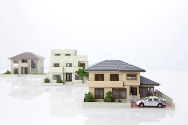 Beyaz arka plandaki küçük ev modelleri, ipotek kavramı