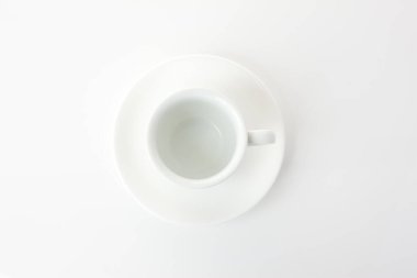 Beyaz arka planda beyaz tabağı olan boş kahve fincanı..