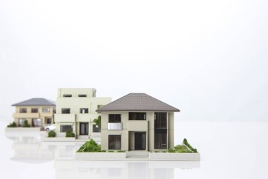 Beyaz arka plandaki küçük ev modelleri, ipotek kavramı