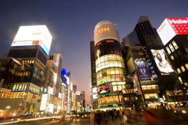Tokyo 'da iş çıkış saatinde Ginza alışveriş merkezinde. Arka plandaki ikonik Sanaa Binası.