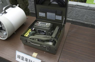 Açık yeşil metal kutunun içindeki askeri iletişim cihazı dışarıda duruyor.