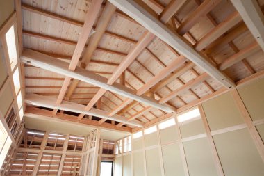 Odasında ahşap tavan ve evde ışık var.