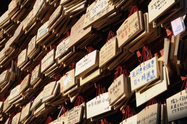 Duvarda asılı ahşap levhalar ve görülebilir yazıtlar var.