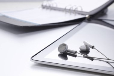 Modern kulaklıklar ve tablet masaya, yakın plan.