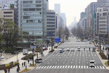 Sisli bir günde Seul 'de kalabalık bir sokak trafiği ve kaldırımlar boyunca yürüyen yayalar var.