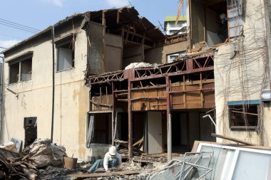 Yıkımın ortasında kask takan işçiler.