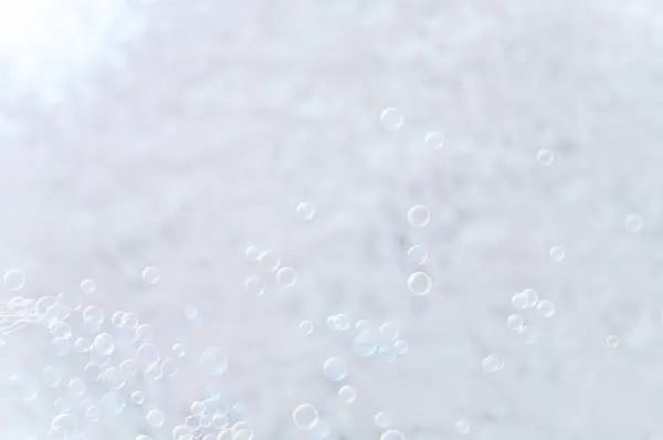 ぼやけたボケのライトの背景にある白い泡 — ストック写真