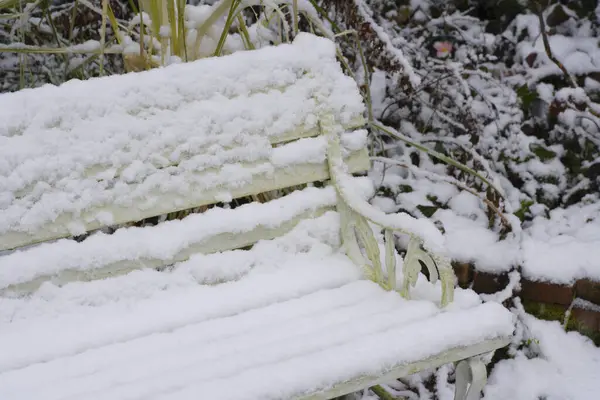 snow covered bench in the park