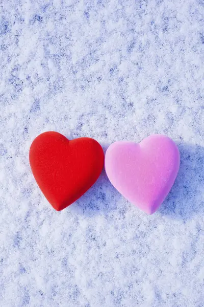 两颗心在雪中 一颗红红的 一颗粉红的 — 图库照片